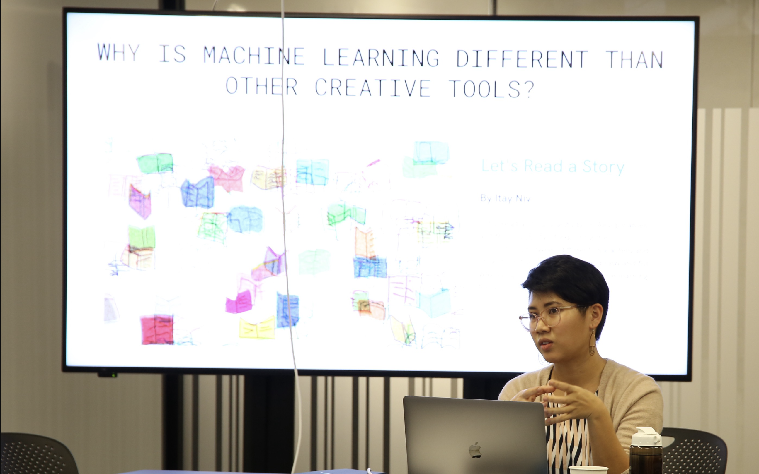 An image of Christina, a filipina person with short hair, in front of a screen that reads why is machine learning different than other creative tools.